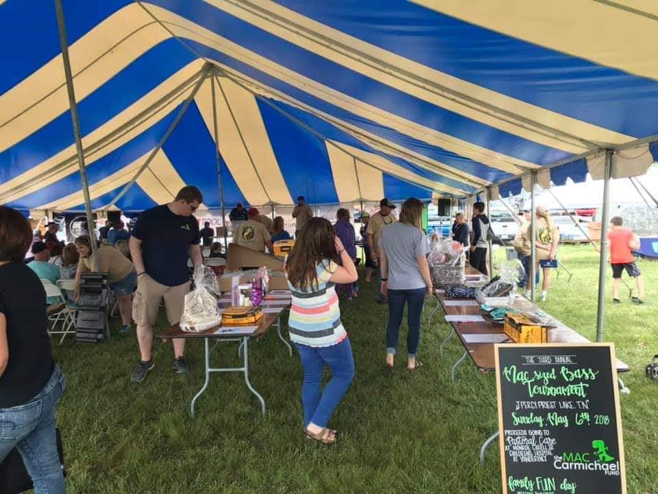 Blue and tan striped tent with festival crowd